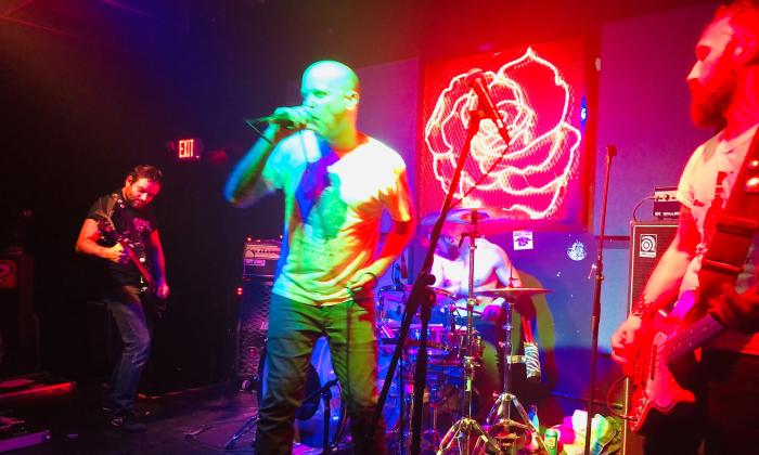 The band Meatwound on stage bathed in colored lights