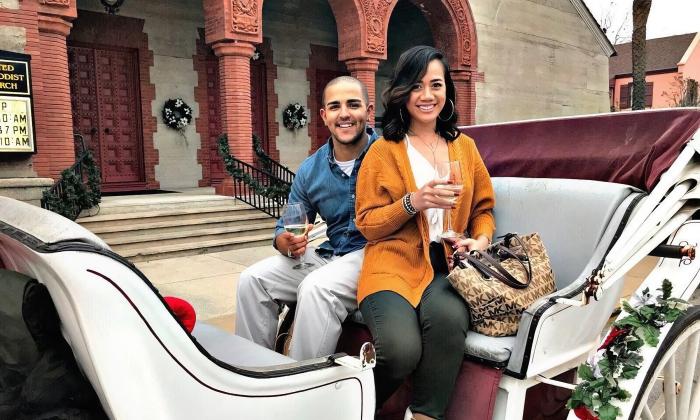 A couple in a white open carriage, parked in front of an historic building