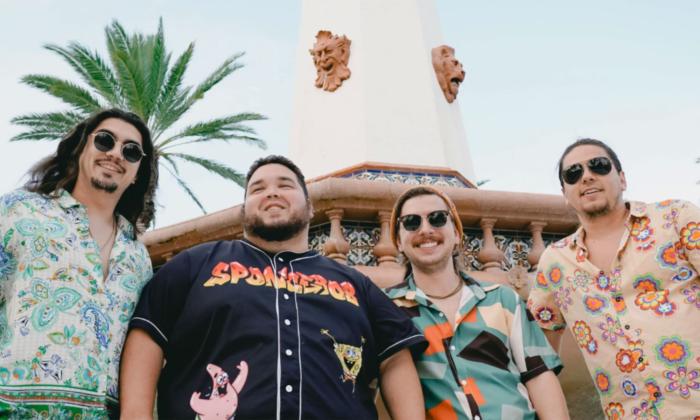 The band Dionysus standing outside under a palm tree