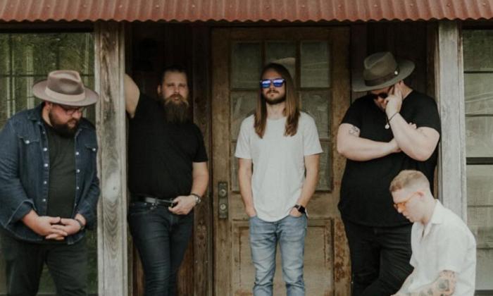 The band Feverdreams standing on a porch of an old house