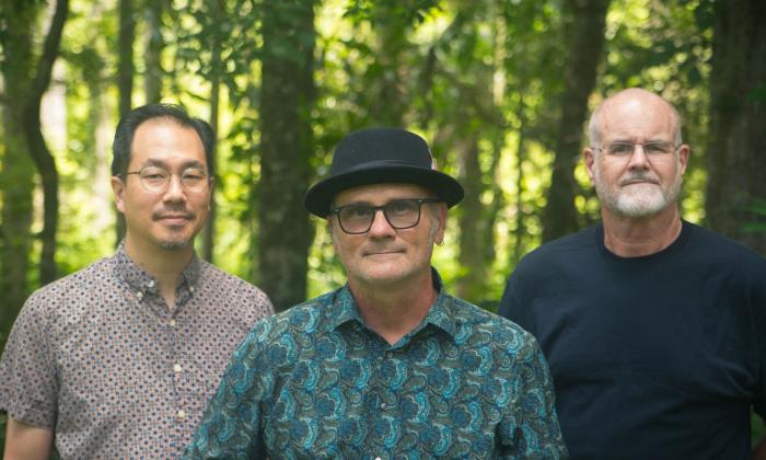 The Rennys band standing together with forest in background.