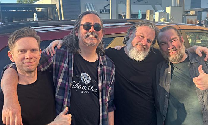 The four members of Chimes standing outside near a van
