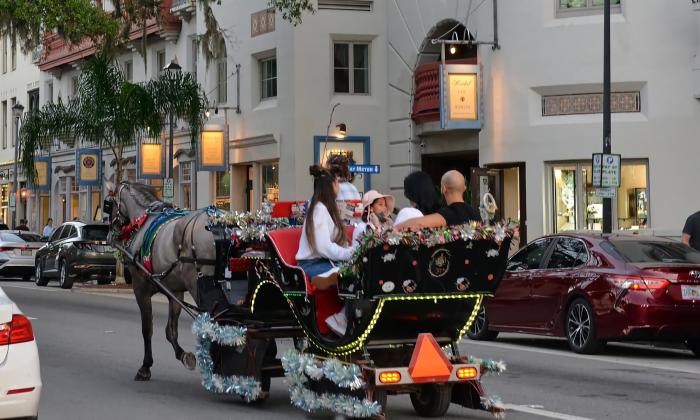 A horse-drawn carriage traveling along Kind Street at dusk during Nights of Lights