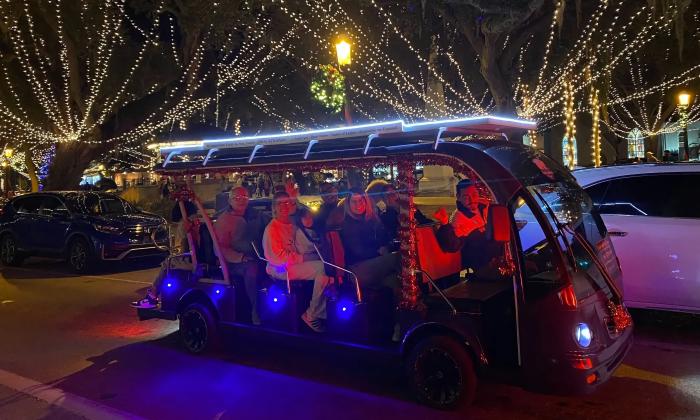 An electric cart with happy passengers on a Nights of Lights tour