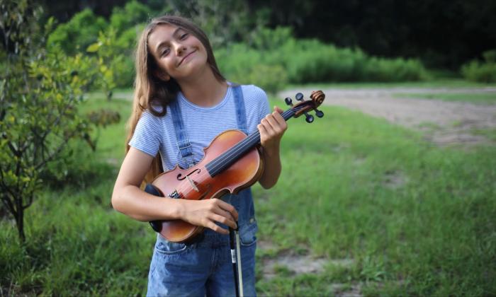 Sydney Strings holding her old fiddle