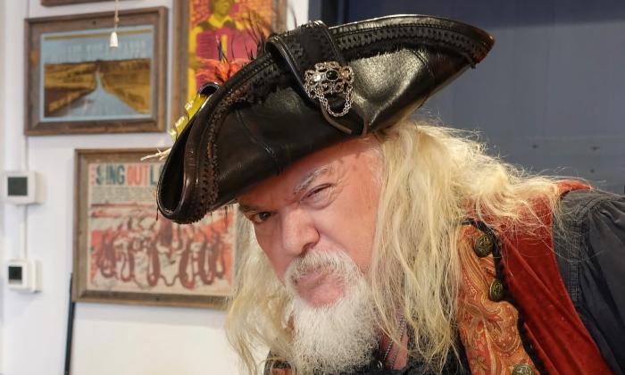 A white-haired pirate captain, mid-wink