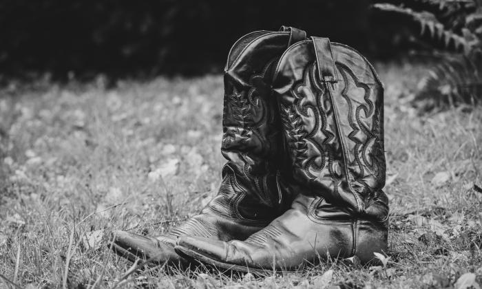 Cowboy boots sitting in a pasture