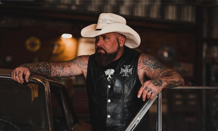 Creed Fisher, country music outlaw standing at an open car door