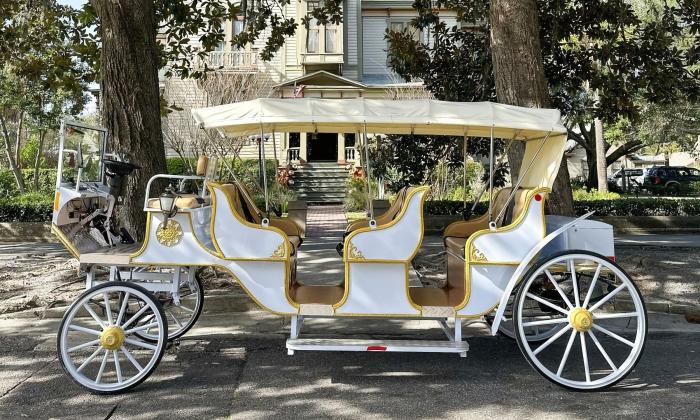 A white and gold horseless carriage replica electric vehicle