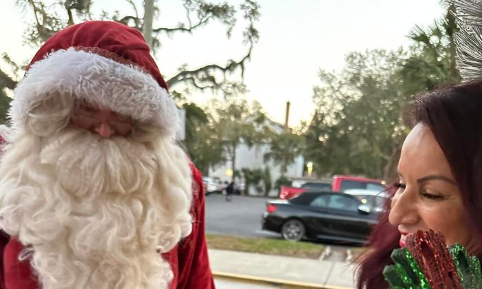 Santa Claus standing with a mom and child in St. Augustine