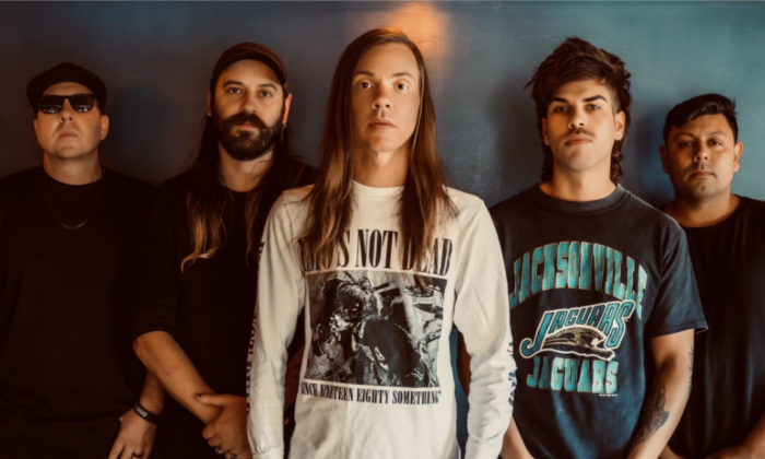 Bandmates from The Red Jumpsuit Apparatus pose in front of a grey backdrop.