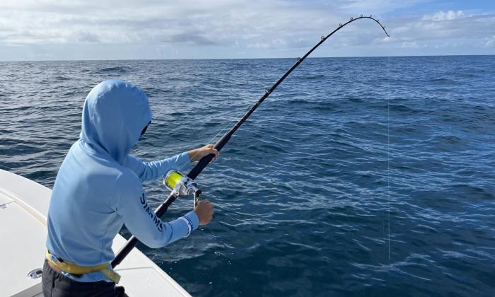 A young angler reeling in a fish