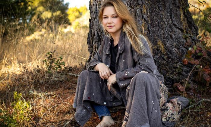 Crystal Bowersox smiles and poses beneath a tree. 