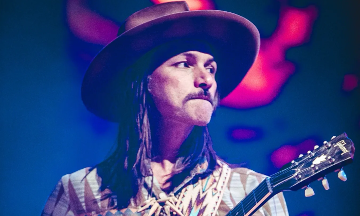 Duane Betts clutches his guitar and performs on stage.