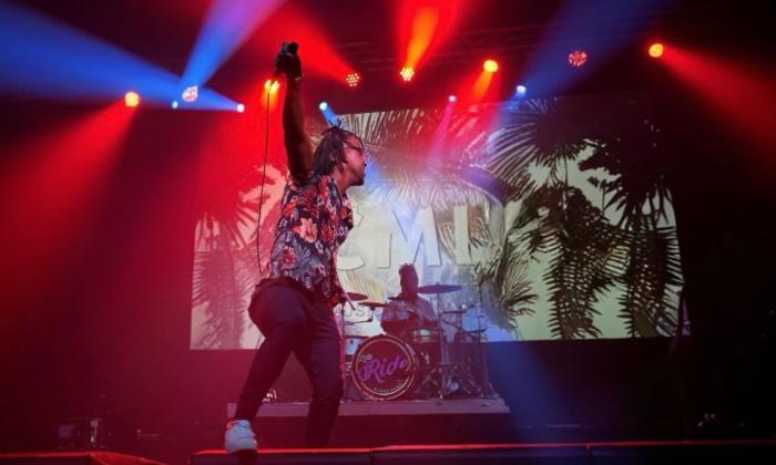 Cellus on stage with colored lights and an energetic performance