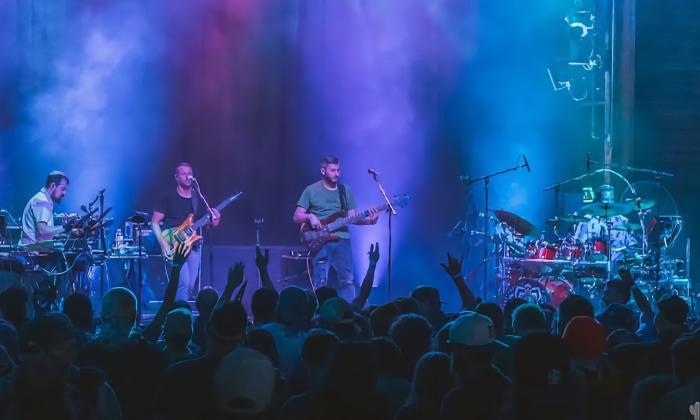 Four members of Spafford, on stage, in blue spotlights