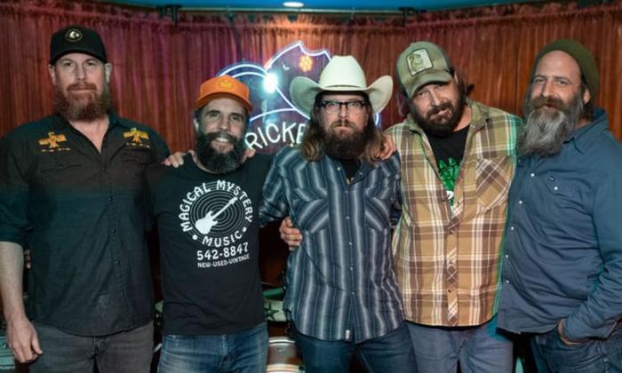 The band Keystone Breakers standing together with arm around each other, on stage