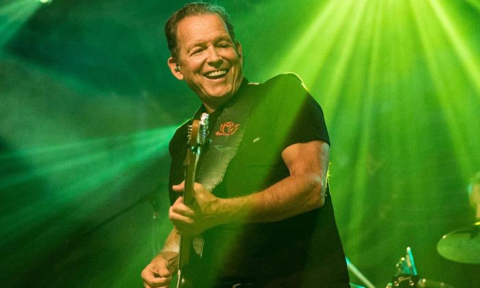 Tommy Castro wears black clothing and performs live on stage.