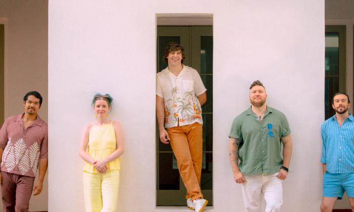 Bandmates from the 502s smile and pose in colorful clothing. 