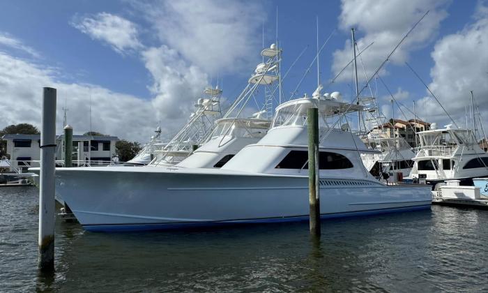 Boats at a marina under a blue sky with scattered white clouds