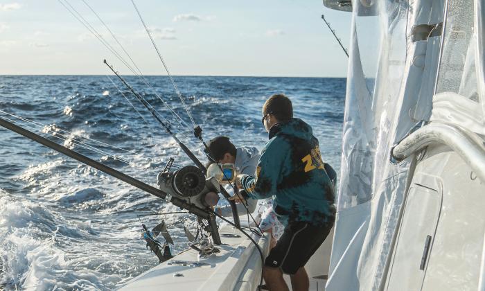 Two fishermen on an off-shore sport-fishing boat