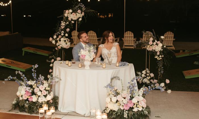 A couple at their wedding reception laughing with guests