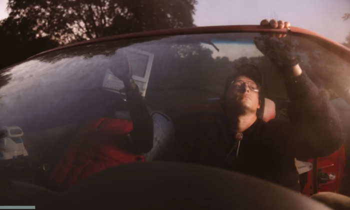 Stephen Wilson Jr. wears glasses and poses in his car.