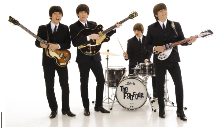 Bandmates from The Fab Four pose in front of a white backdrop.