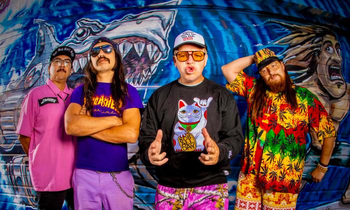 The band Badfish in front of a shark mural