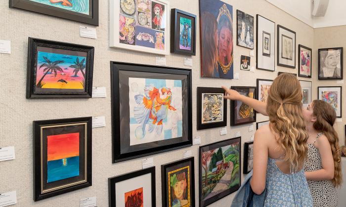 Girls pointing at displayed art