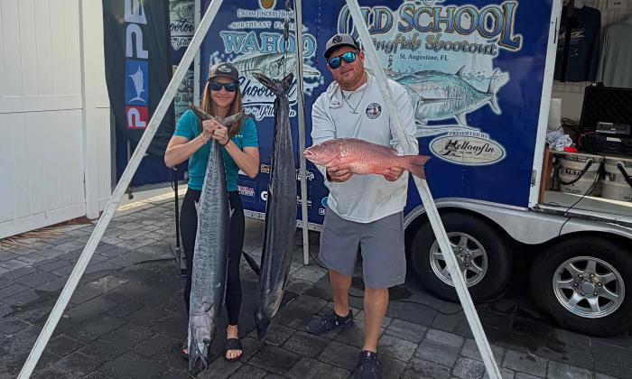 A man and a woman with three fish they caught during the Wahoo Shootout