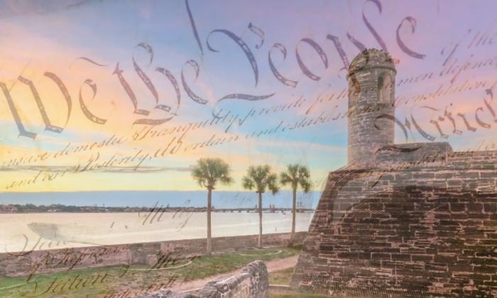 An old postcard photo of the Castillo at sunrise with words from the Declaration of Independence