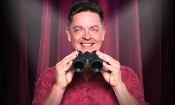 Jim Breuer smiles while clutching binoculars.