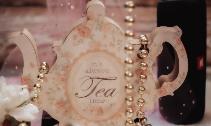 A tea cup with beads dangling over top