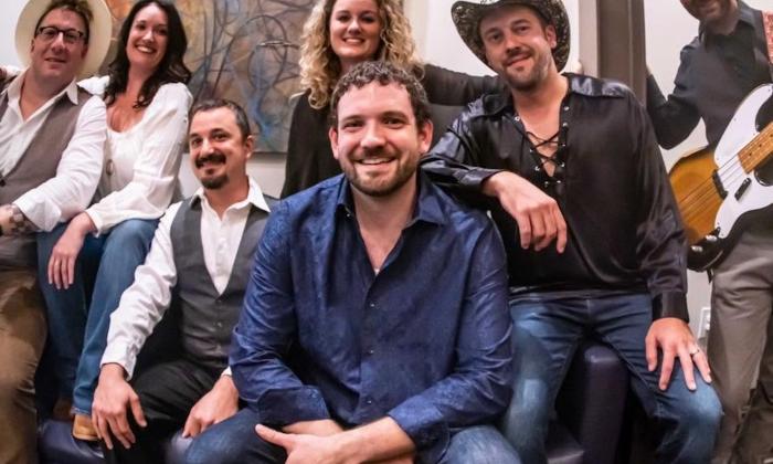 Bandmates from The Seven Wonders huddle together and strike a pose.