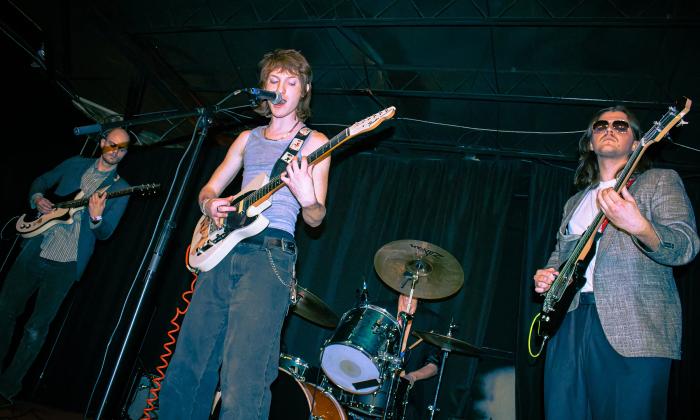 Anthony Mikus, with a guitar in center front, surrounded by the other three band members