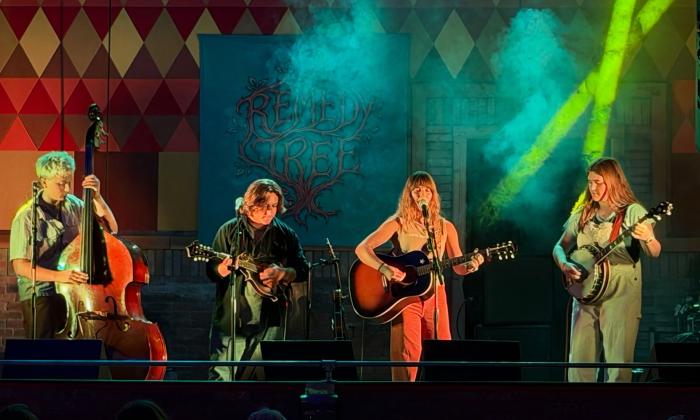 The four members of Fox Creek performing on a stage with colorful lights