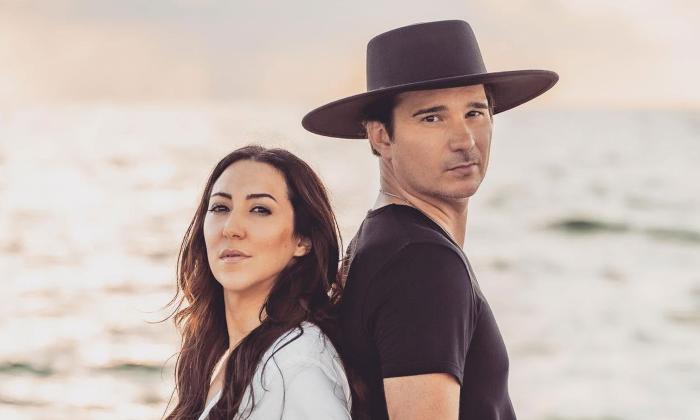 Songwriting duo Blackbird Morning standing back-to-back at the ocean.