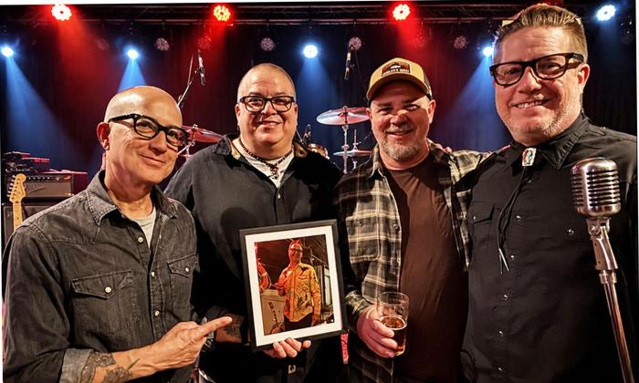 Honest Liars band standing together on stage, behind a mic