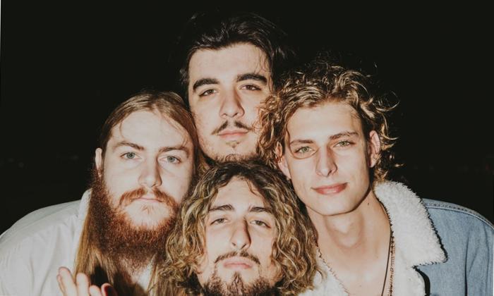 The band Magi standing with heads together