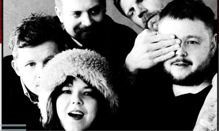 Bandmates from Of Monsters and Men wear dark clothing and pose in front of a grey backdrop.