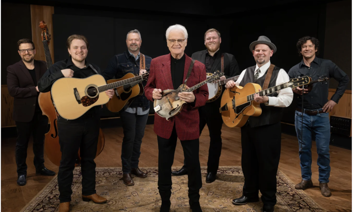 Bandmates from Ricky Skaggs and Kentucky Thunder smile while holding their musical instruments.