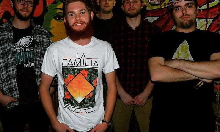 The Sons of Paradise bandmates flash bright smiles while posing together in front of a vibrant graffiti-covered wall.