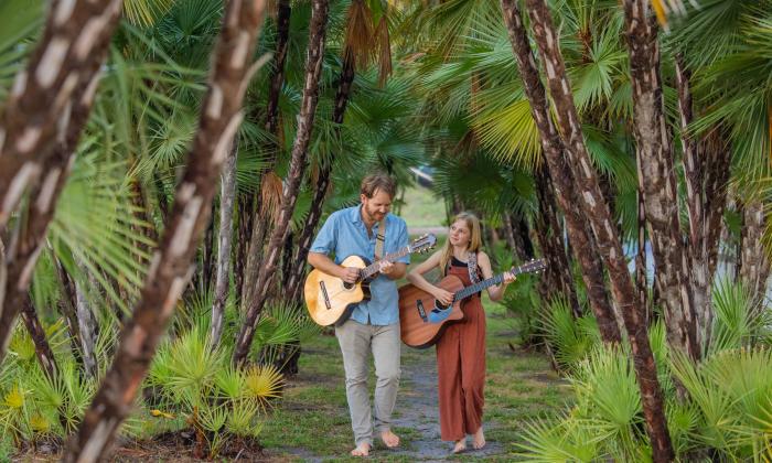 Bystrom & Bear playing guitar in the woods