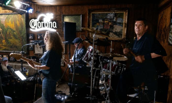 The trio, Ancient City Rock, on stage at TradeWinds Lounge