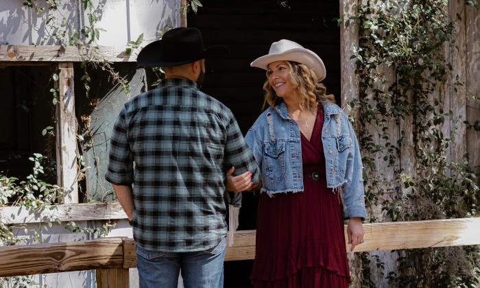 A couple standing outside a barn