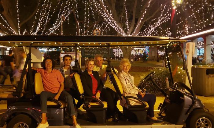 A Gold Tours electric EV with a family aboard for a Nights of Lights Tour