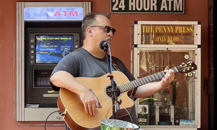 Musician Joe Schauer playing outside in the square at St. George Inn