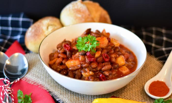 A bowl of chili topped with garnishes