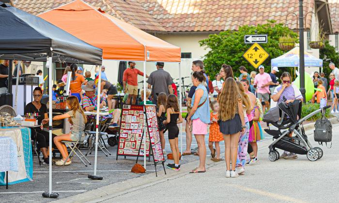 Families standing in line for face painting at a local festival